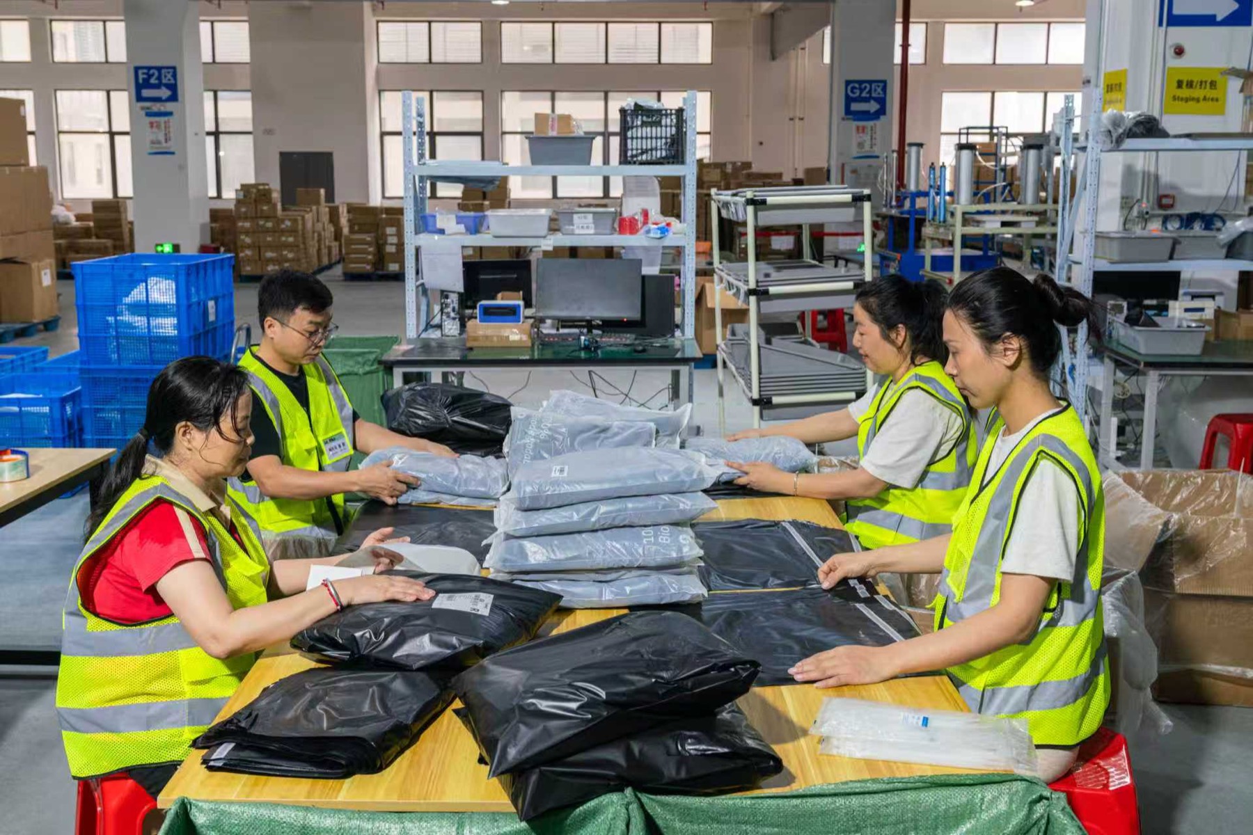 Warehouse team packing product orders at a fulfillment table